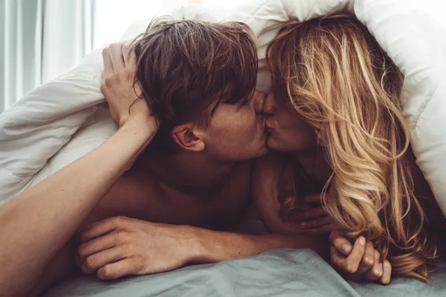 ベッドでキスをするカップル