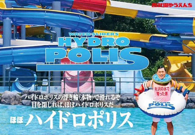 西武園ゆうえんちのウォータースライダー「HYDRO POLIS」前で、としまえんのハイドロポリスの浮き輪を持つ春日さん。「ほぼハイドロポリス」の文字