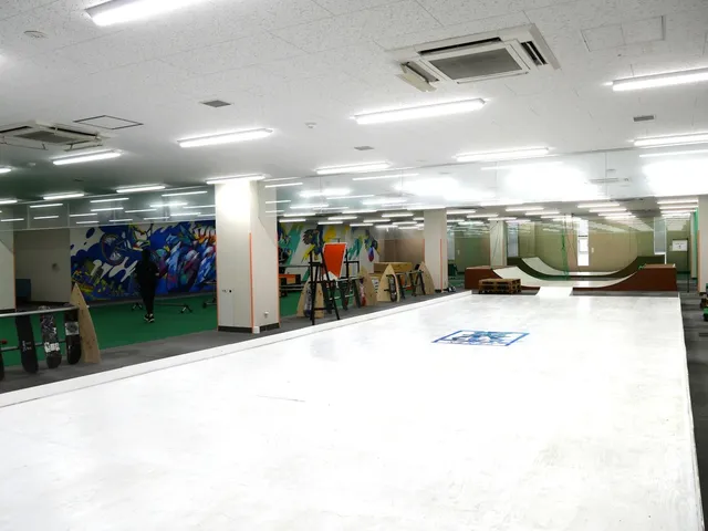 裏トシマのスケートボードエリア全景。白いフラットスペースとランプが設置され、壁面にはカラフルなグラフィティアートが描かれている