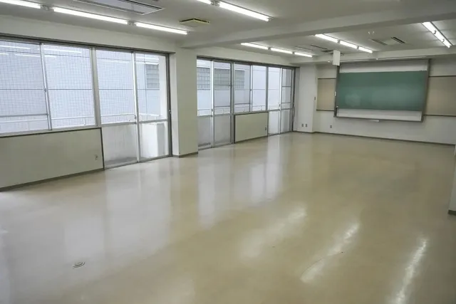 飯田橋の学校跡地にある教室スペース。黒板・大きな窓・蛍光灯が残る空き教室で、公演会場となる実際の空間