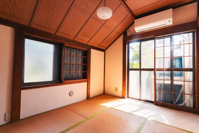 リノベーション後の和室。畳が張り替えられ、木の天井板と格子窓が残る。右手の大きな格子ガラス戸から陽光が差し込んでいる