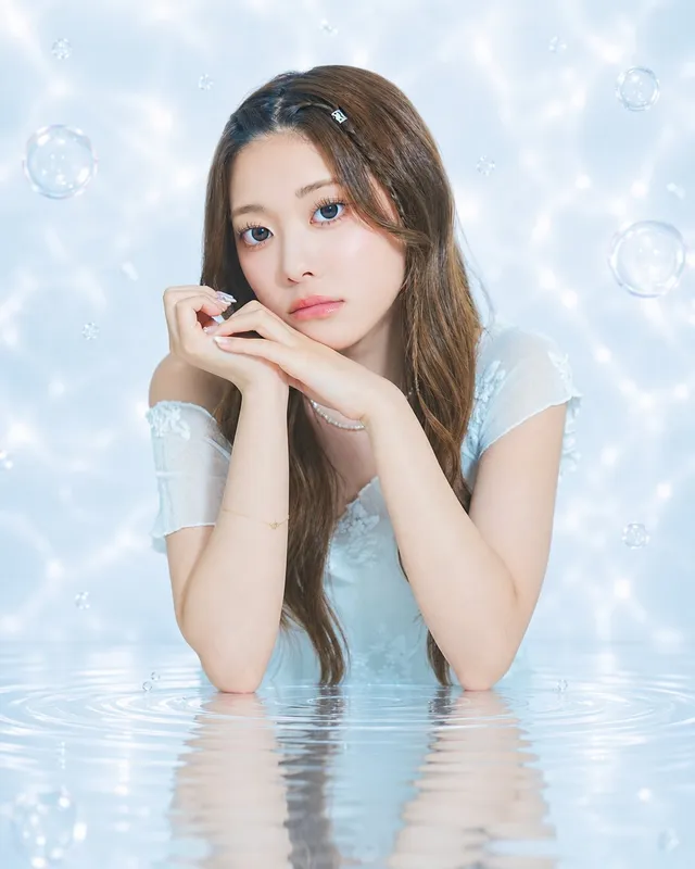 10代のメンバーの一人が水面に手を添えて微笑む単独カット