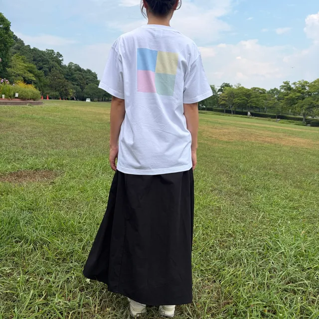 公園でCANVASのTシャツを着た女性の後ろ姿、背中の4色マス目デザインがはっきり見える
