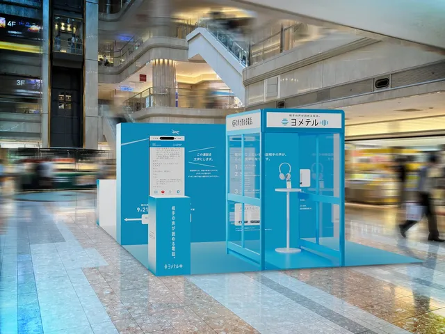 羽田空港マーケットプレイスに設置された読める電話ボックスと、通話内容がリアルタイムで文字化される様子を映す案内パネル