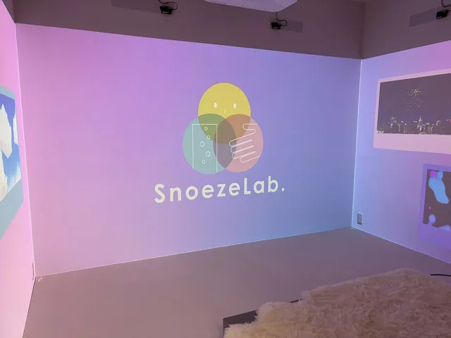 投影で雲や夜景、抽象模様が壁に映し出されたSnoezeLab.の多感覚ルーム全景