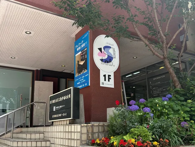 渋谷区立勤労福祉会館1階入口にあるShibuya well-being Lab.の看板と花壇