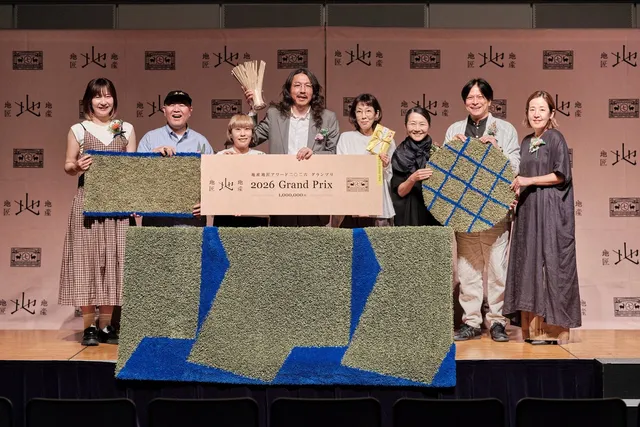 地産地匠アワード2026グランプリの授賞式で、開発チームやitiitiのデザイナーらがizaizaのラグと賞状を持って登壇する集合写真