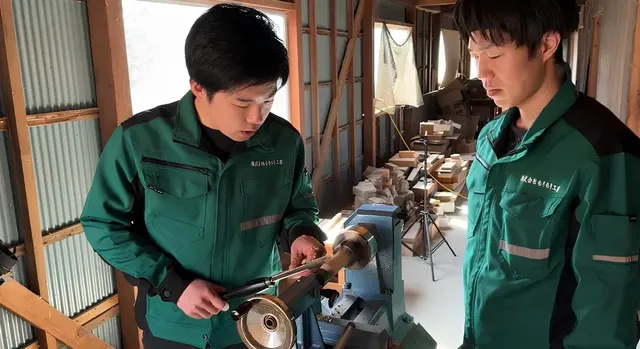 もりもり工房の職人が能登の古材を旋盤で加工している製作風景