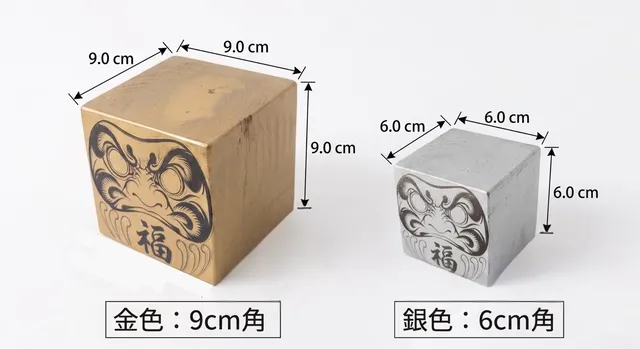 金9cm角と銀6cm角の達磨のサイズを並べて示した写真
