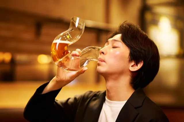 男性がふらつくビアグラスでビールを飲む使用シーン