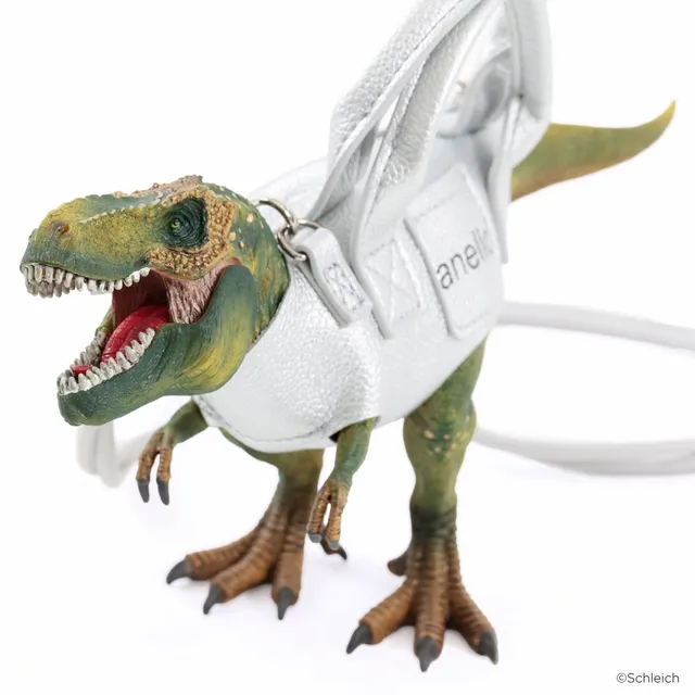 シルバーのバッグを着た恐竜フィギュアの頭部アップ。しっぽ用の開口部や体形に合わせた設計がわかる