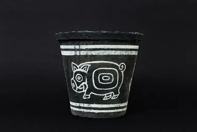黒い陶器に猪と幾何学模様が白線で描かれたパンジャ王国の民具とされる器