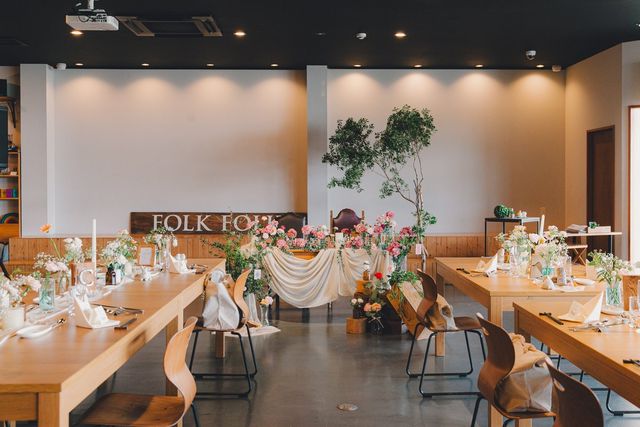 披露宴会場に設置されたFOLK FOLKのロゴ看板と花で装飾された新郎新婦席